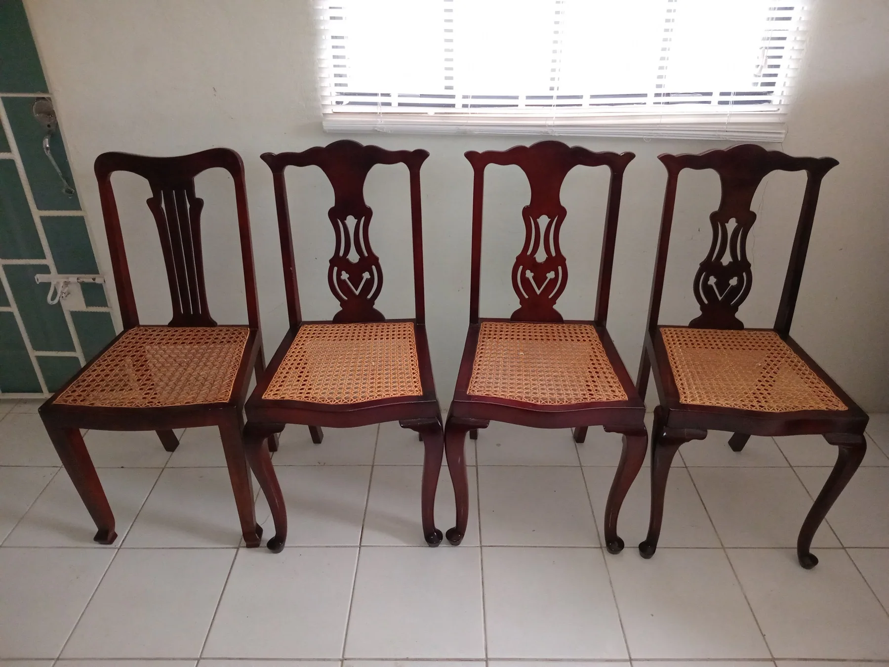 Four wooden chairs with woven seats