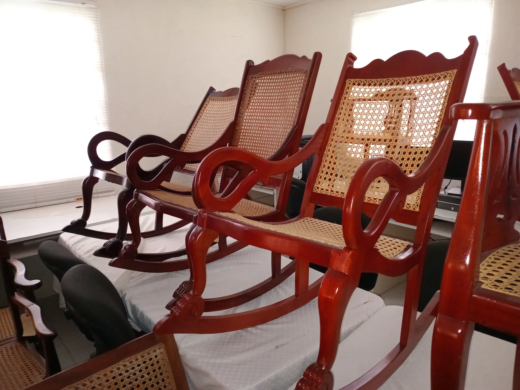 Polished wooden rocking chairs with caned backs