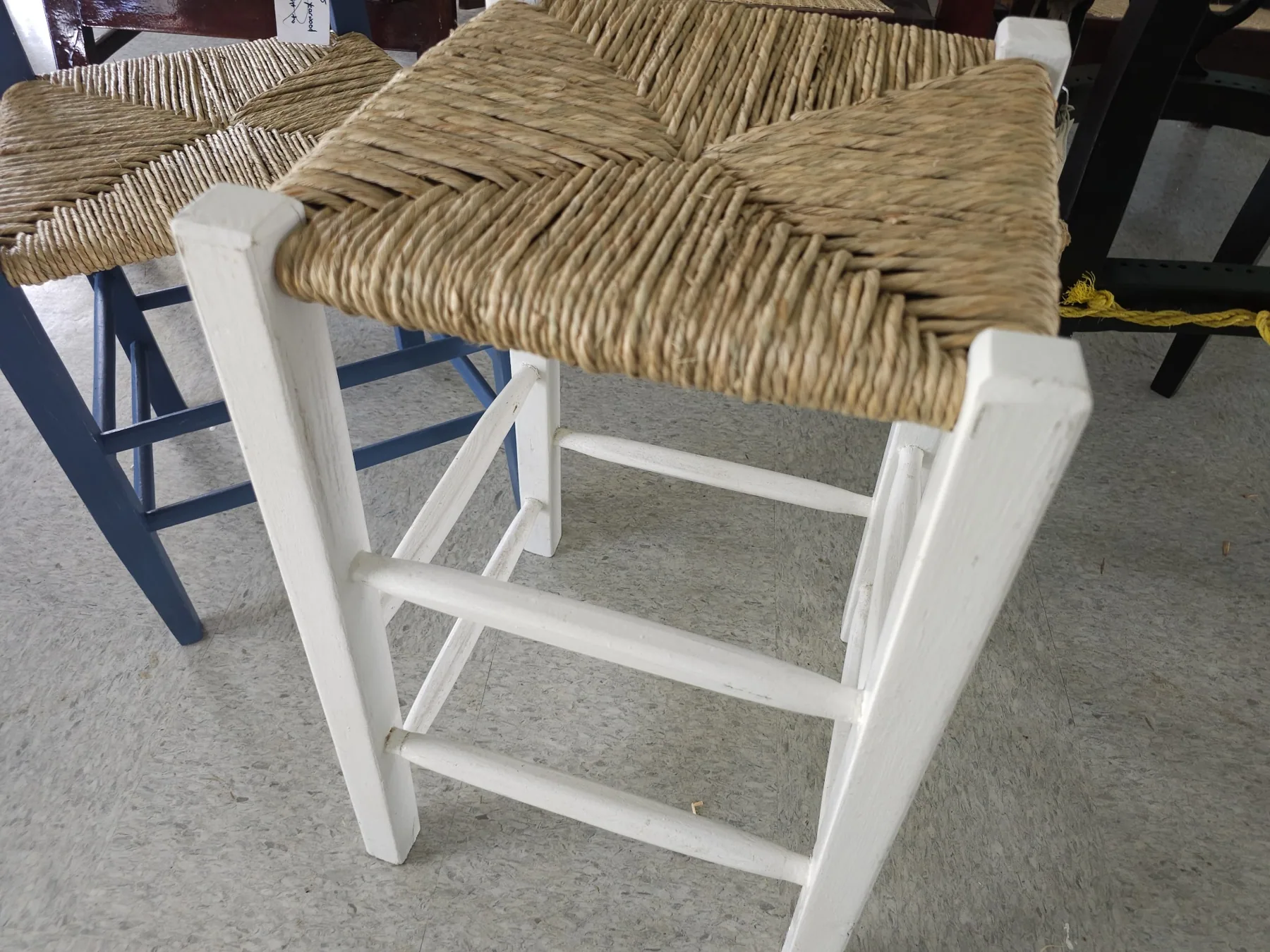 White wooden stool with woven straw seat