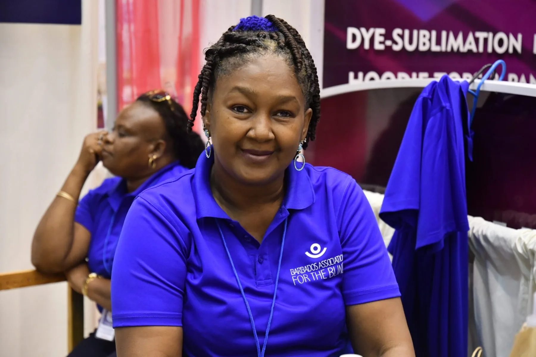 Woman wearing a Barbados Association for the Blind polo shirt at a community event